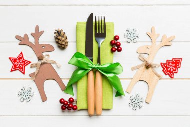 Noel süslemeleri ve ahşap arka planda ren geyiği olan peçetedeki yeni yıl aletlerinin en üst görüntüsü. Noel yemeği konseptini kapat. .