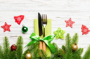 Ahşap arka planda noel süslerinin en üst görüntüsü. Peçetedeki çatal ve bıçak kurdeleyle bağlanmış ve senin tasarımın için boş bir alan. Yeni yıl şablonu kavramı.