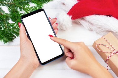 Kadın alıcı kopya alanı ile akıllı telefon ekranında sipariş yapar. Kış tatil satış. Noel online alışveriş.