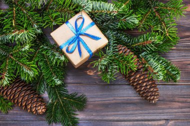 Noel hediye kutusu ahşap masa arka plan, Ladin şube, çam kozalakları, çerçeve, üstten görünüm, metin için yer.