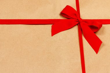 Kahverengi kutunun arkasında kırmızı bir bayram yayı var. Üst görünüm kopyalama alanı. Ayarlanmış.