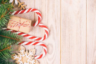 Noel hediyesi kutusu, kar taneli şeker kamışı ve ahşap masada köknar ağacı dalı. Ayarlanmış.