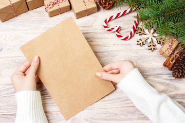 Eller neşeli Noel kartı ve zarf tutun. Noel dekorasyon arka plan. Düz yatıyordu, en iyi görünümü.