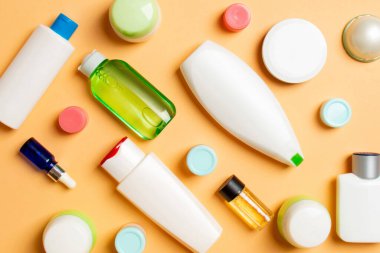 Plastik gövde bakımı şişesi düz kompozisyonu ve renkli arka plan boşluğuna kozmetik ürünler dizayn edilmişti. Beyaz Kozmetik kapları kümesi, kopya alanı ile üst görünüm.