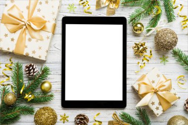 Digital tablet mock up with rustic Christmas decorations for app presentation top view with empty space for you design. Christmas online shopping concept. Tablet with copy space on colored background.