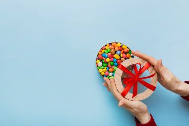 Renkli kutuda lezzetli şekerlemeleri olan kadın elleri.