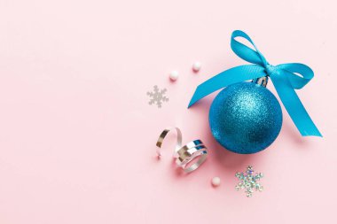 Christmas ball on colored background. decoration bauble with ribbon bow with copy space.