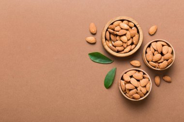 Fresh healthy Almond in bowl on colored table background. Top view.