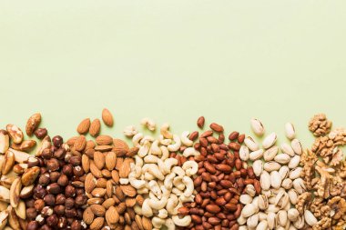 different nuts frame background. Close up, top view, flat lay with vopy space. Walnut, pistachios, almonds, hazelnuts and cashews.