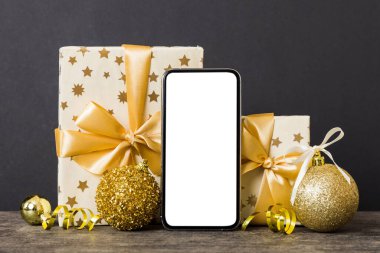 Digital phone mock up with rustic Christmas decorations for app presentation with empty space for you design. Christmas online shopping concept. Tablet with copy space on colored background.