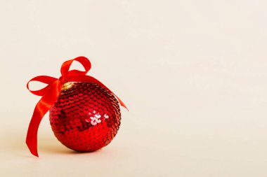 Christmas ball on colored background. decoration bauble with ribbon bow with copy space.