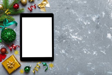 Digital tablet mock up with rustic Christmas decorations for app presentation top view with empty space for you design. Christmas online shopping concept. Tablet with copy space on colored background.