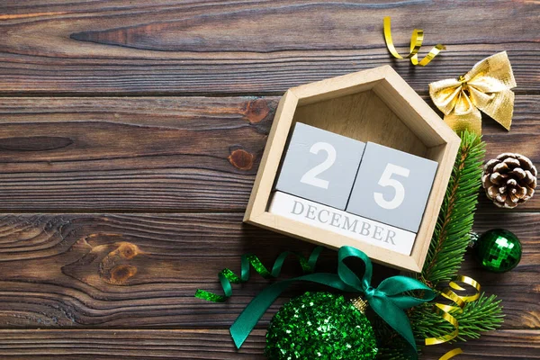 Christmas calendar 25 december. Christmas gift, fir branches, pine cones. Flat lay, top view. New Year decorations on a colored background.