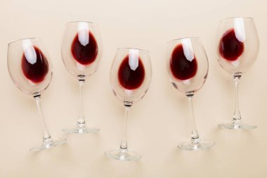 Şarap tadımında bir sürü kırmızı şarap. Renkli arka planda kırmızı şarap kavramı. Üst görünüm, düz dizayn.