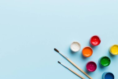 Boya ve fırçalı palet, yakın çekim. Boşluğu olan üst görünüm. Yaratıcılık için işyeri. ev öğretmenliği kavramı çizimi.