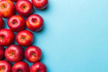 Renkli arka planda bir sürü kırmızı elma, üst manzara. Tasarım veya metin için kopyalama alanı olan taze elma görünümlü sonbahar deseni.