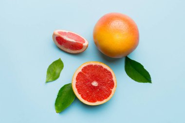 Renkli arka planda sulu greyfurt dilimli taze meyve greyfurdu. Üst Manzara. Uzayı kopyala yaratıcı yaz konsepti. Minimum düzlükte turunçgillerin yarısı kopyalama alanı ile yatar.