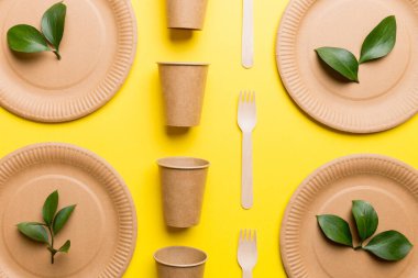 Açık beyaz masa arkaplanındaki boş, tek kullanımlık çevre dostu tabaklar, bardaklar, çatal bıçaklar. Üst Manzara. Biyo-çözünebilir el yapımı yemekler. Geri dönüşüm konsepti. Yakın plan..