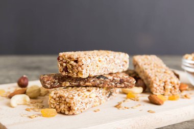 Arka planda çeşitli granola barlar var. Mısır gevreği gofretleri. Yulaf, fındık ve böğürtlenli kahvaltı barları, yakın çekim. Süper yiyecek konsepti.