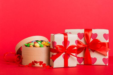 Valentine day composition: sweet candy, with gift boxes with bow and red felt hearts, photo template, background. Perspective with copy space.