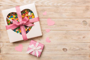 Valentine day composition: sweet candy, with gift boxes with bow and red felt hearts, photo template, background. Top View with copy space.