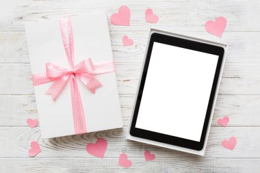 Gift box of open tablet for the holidays with a bow top view.