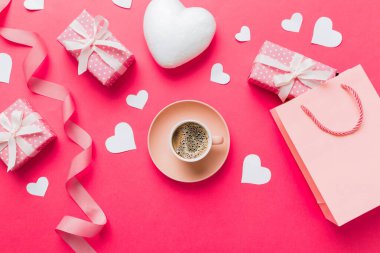 Mug coffee and gift box on colored background. Flat lay composition. Holiday concept.