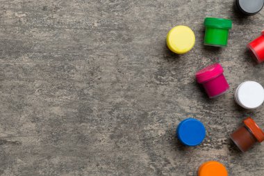 Renkli arka planda farklı renkte gagalı kavanozlar. Hobi resim. Boşluğu olan üst görünüm. Yaratıcılık için işyeri. ev öğretmenliği kavramı çizimi.