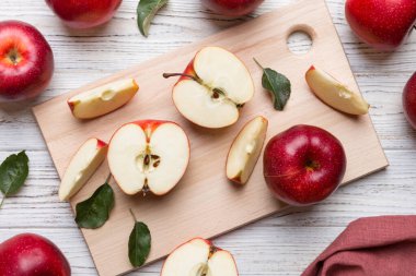 Yeşil yapraklı taze kırmızı elmalar. Bıçakla kesme tahtası. Üst görünüm.