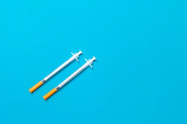 Renkli arka planda fotokopi alanı olan iki insülin şırıngasının üst görüntüsü. Yüksek seviyedeki glikoz konsepti.