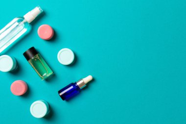 Kozmetik SPA marka modeli, fotokopi alanı olan üst görünüm. Renkli arka planda duran krema tüpleri ve kavanozları..