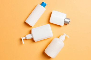 Renkli arkaplanda izole edilmiş Beyaz Kozmetik konteynırları seti, fotokopi alanı ile üst görünüm. Senin için bir grup plastik kaplar ve boş bir yer tasarladın..