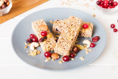Arka planda çeşitli granola barlar var. Mısır gevreği gofretleri. Yulaf, fındık ve böğürtlenli kahvaltı barları, yakın çekim. Süper yiyecek konsepti.
