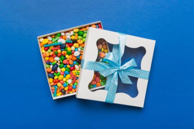 Box with sweet chocolate candies on color background, Various candy sweets. Valentines day gift box. Top view flat lay with copy space.