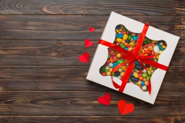 Valentine day composition: sweet candy, with gift boxes with bow and red felt hearts, photo template, background. Top View with copy space.