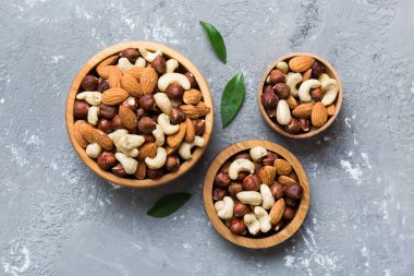 Renkli masadaki ahşap kasede fındık çeşitleri. Ceviz, fındık, ceviz, badem. Fındık Üst görünümü ile kopyalama alanını karıştır.