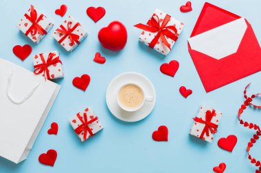 Mug coffee and gift box on colored background. Flat lay composition. Holiday concept.