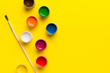 Boya ve fırçalı palet, yakın çekim. Boşluğu olan üst görünüm. Yaratıcılık için işyeri. ev öğretmenliği kavramı çizimi.