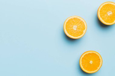 Renkli arka planda taze meyve portakalı dilimleri. Üst Manzara. Uzayı kopyala yaratıcı yaz konsepti. Minimum düzlükte turunçgillerin yarısı kopyalama alanı ile yatar.