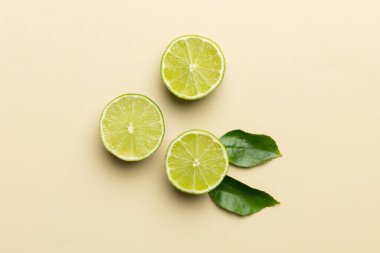 Yeşil yapraklı kireç meyveleri ve beyaz arka planda yarım dilim kesilmiş. Üst Manzara. Kopyalama alanı olan düz.