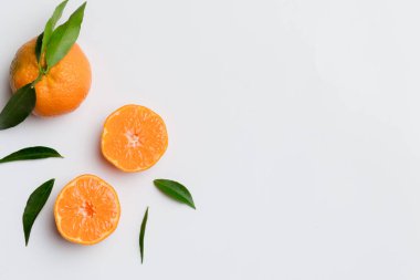 Renkli arkaplanda yeşil yaprakları, üst görünümü, metin için alanı olan bir sürü olgun mandalina..