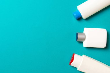 Renkli arkaplanda izole edilmiş Beyaz Kozmetik konteynırları seti, fotokopi alanı ile üst görünüm. Senin için bir grup plastik kaplar ve boş bir yer tasarladın..