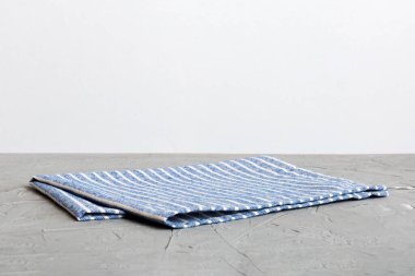 top view with blue kitchen napkin isolated on table background. Folded cloth for mockup with copy space, Flat lay. Minimal style.