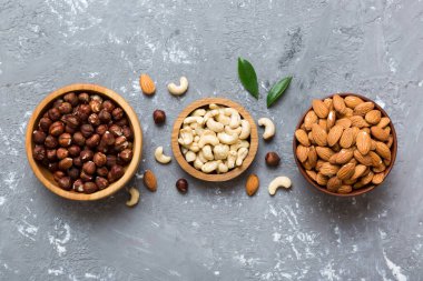 Renkli masadaki ahşap kasede fındık çeşitleri. Ceviz, fındık, ceviz, badem. Fındık Üst görünümü ile kopyalama alanını karıştır.