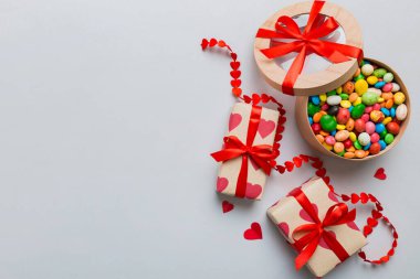 Valentine day composition: sweet candy, with gift boxes with bow and red felt hearts, photo template, background. Top View with copy space.