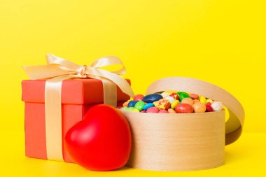 Valentine day composition: sweet candy, with gift boxes with bow and red felt hearts, photo template, background. Perspective with copy space.