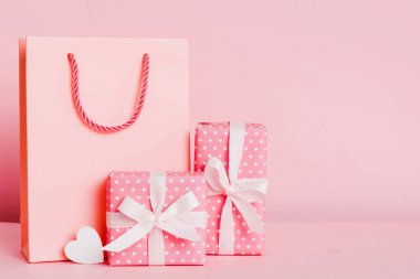 Shopping bag with gift box on colored background perspecrive view. Space for text holiday concept.