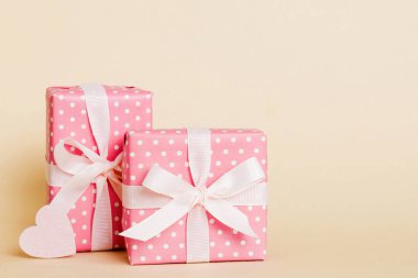 gift box with red bow and red heart on colored background. Perspective view. Flat lay.