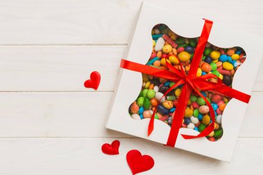 Valentine day composition: sweet candy, with gift boxes with bow and red felt hearts, photo template, background. Top View with copy space.