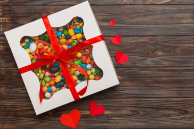 Valentine day composition: sweet candy, with gift boxes with bow and red felt hearts, photo template, background. Top View with copy space.